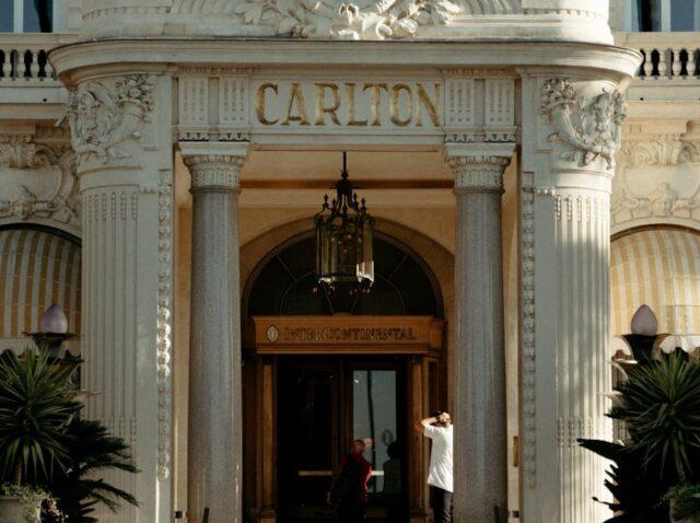 An ornate entrance of the luxury Carlton Hotel in Cannes, France, showcasing grandeur and architectural beauty.